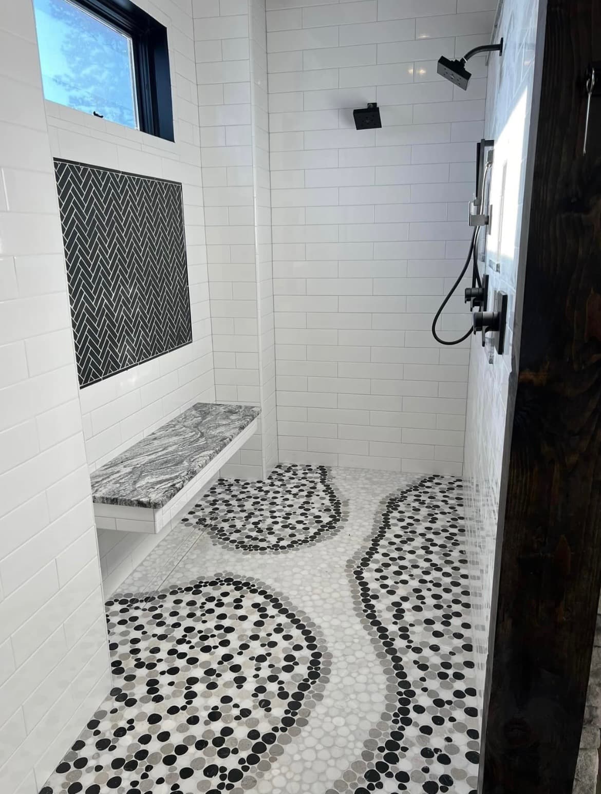 Walk-in shower with natural pebble mosaic floor tile installation in Menifee home