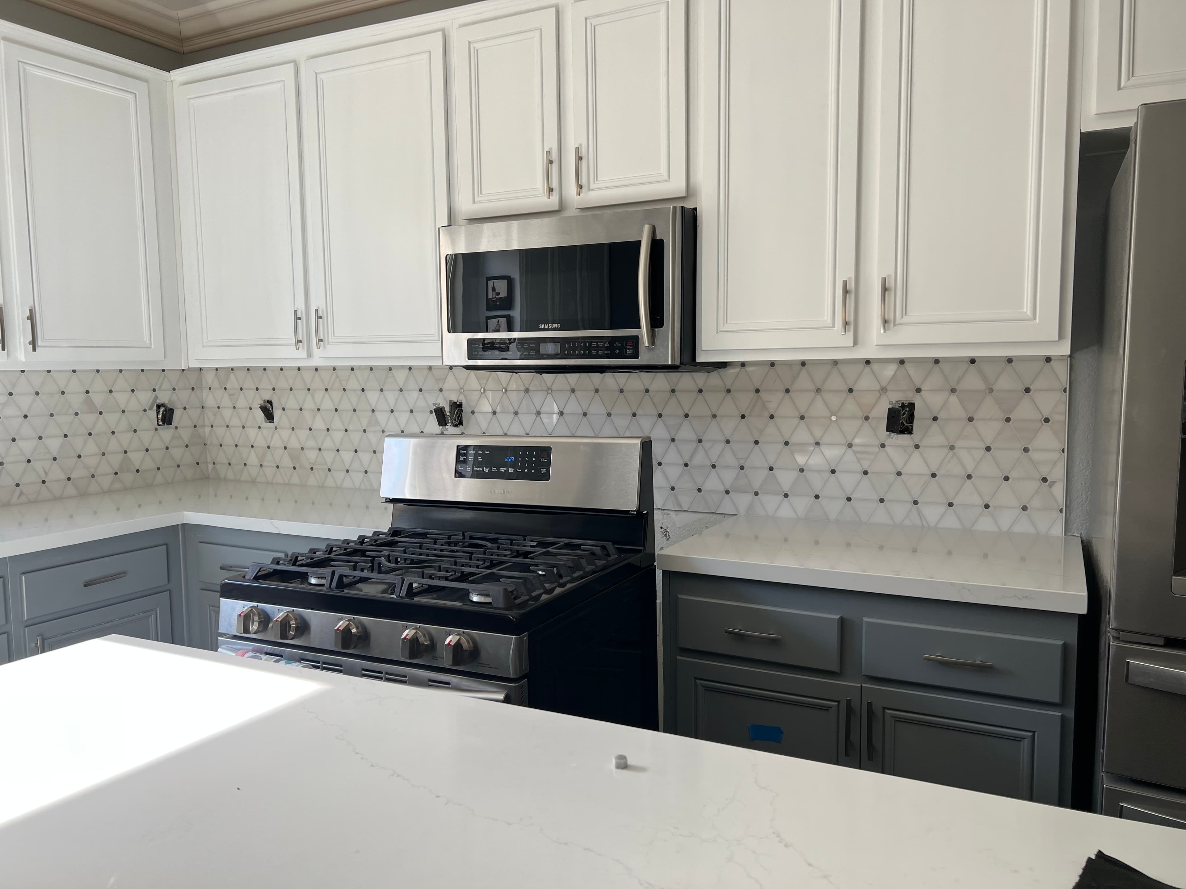Kitchen with elegant diamond pattern marble mosaic backsplash in Riverside home
