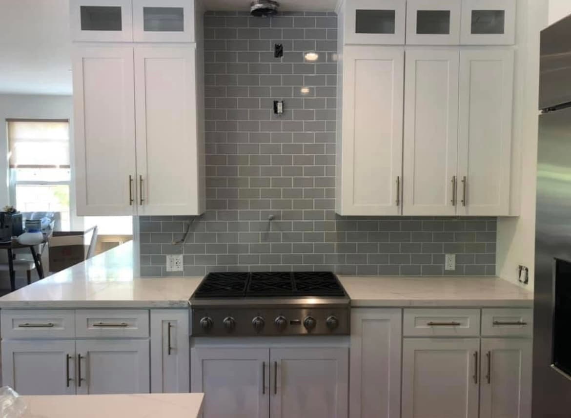 Gray subway tile kitchen backsplash with white cabinets in Newport Beach coastal home