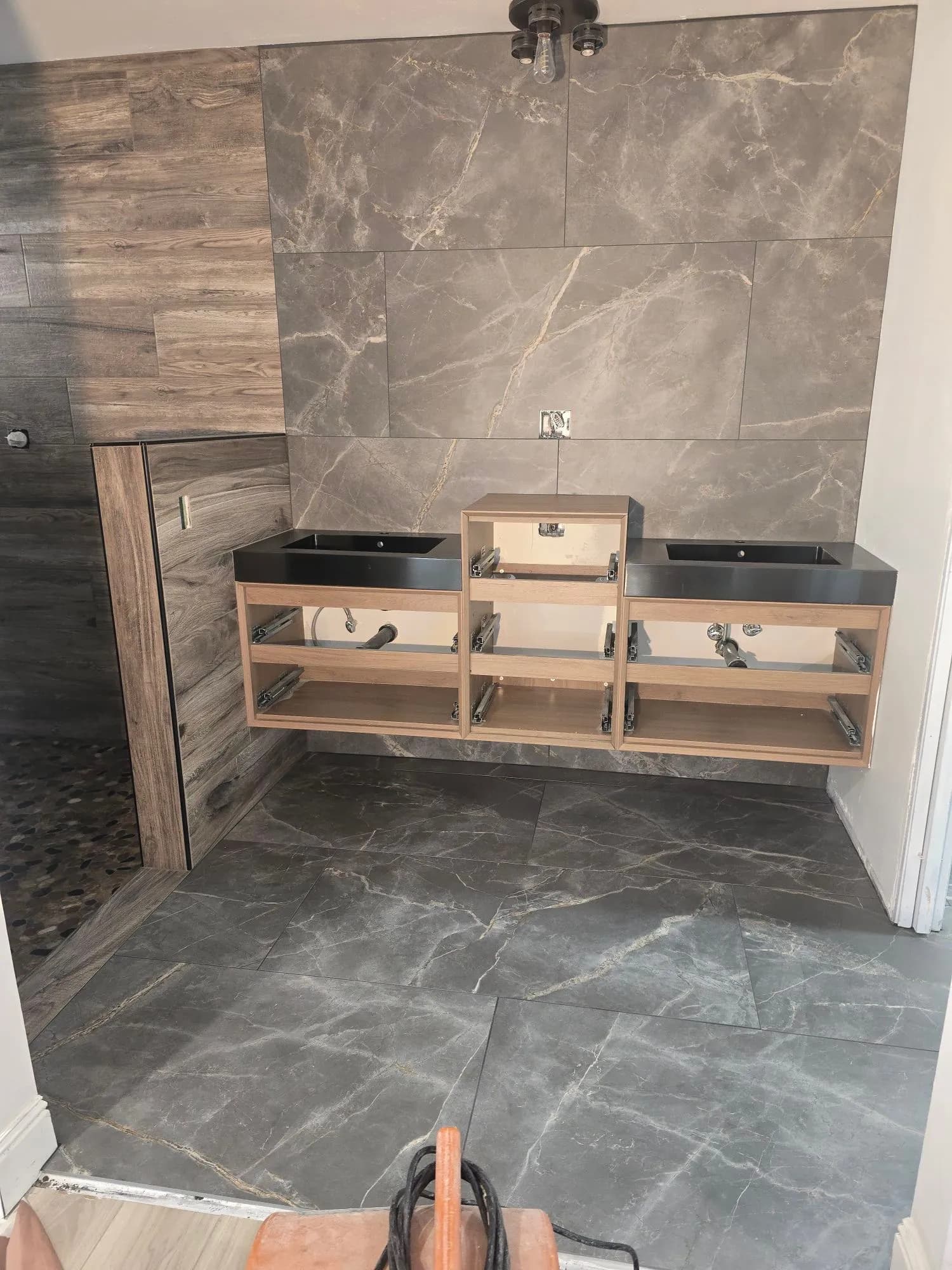 Full bathroom renovation with marble-look porcelain floor and floating double vanity in Fallbrook home