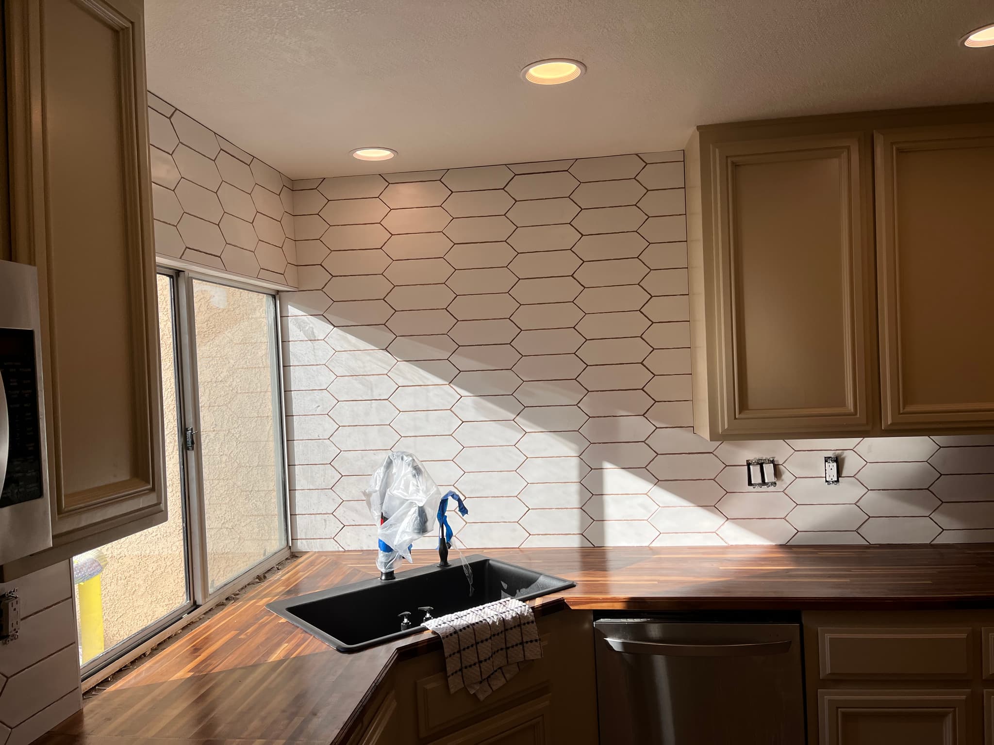 Custom elongated hexagon tile backsplash with butcher block counters in Sun City kitchen